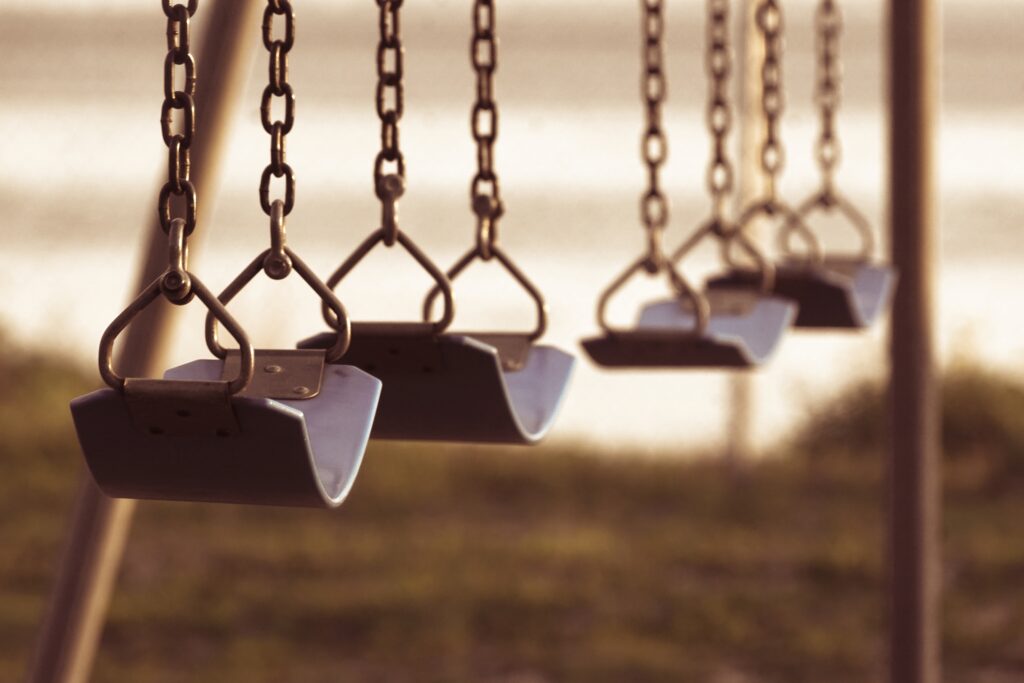 A close-up sepia shot of swings.